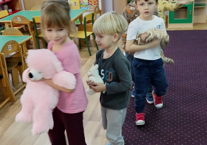 Dzieci ustawione w pociągi jadą ze swoimi misiami w podróż