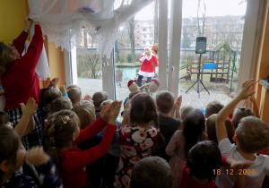 Dzieci uczestniczą w proponowanych zabawach przez asystentkę Mikołaja