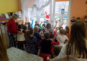 Dzieci uczestniczą w proponowanych zabawach przez asystentkę Mikołaja