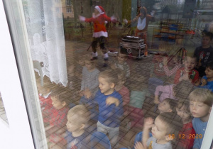 Dzieci oglądają występ asystentki Mikołaja