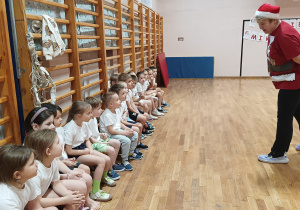 Nauczycielka wychowania fizycznego wita się z dziećmi.