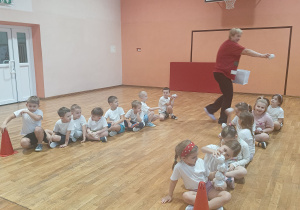 Pani rozdaje papierowe kule śnieżne.