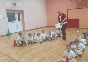 Pani rozdaje papierowe kule śnieżne.