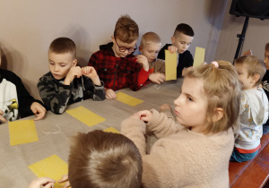 Dzieci wykonują własną świecę z wosku.