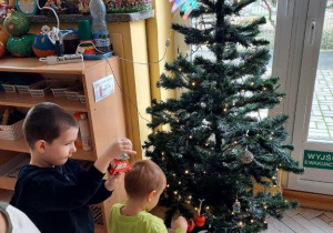 Dzieci ubierają choinkę
