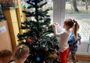 Dzieci ubierają choinkę
