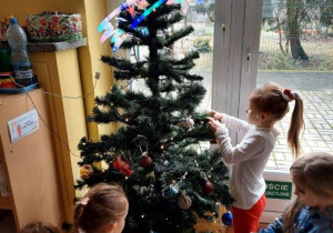 Dzieci ubierają choinkę