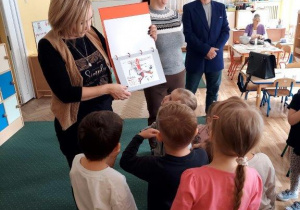 Pracownik poczty pokazuje projekty znaczków.