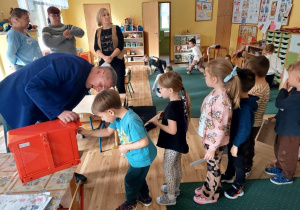 Dzieci wkładają listy do skrzynki pocztowej.