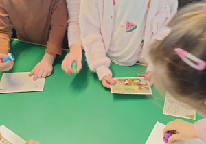 Dzieci stemplują kartki świąteczne.