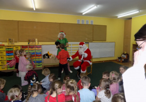 Mikołaj rozdaje prezenty dzieciom