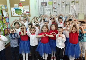 zdjęcie dzieci, które pokazują dla dziadków serca ułożone z dłoni