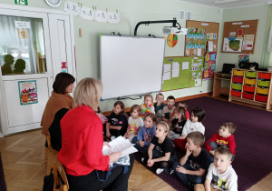 Pani rozmawia z dziećmi o numerach alarmowych