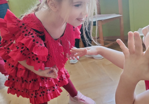 Dziewczynka staje w pozie podczas zabawy