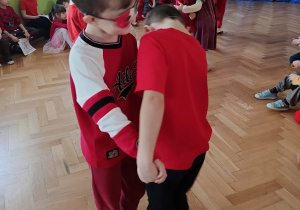 Dzieci tańczą parach na gazecie.