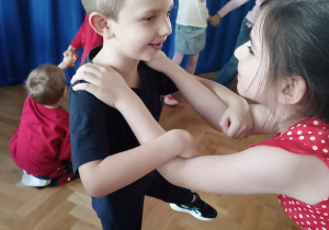 Dzieci w parach przybierają pozę.