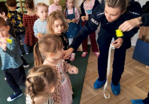 Dzieci otrzymują breloki odblaskowe