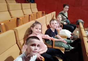 Dzieci siedzą na widowni w Akademii Muzycznej i czekają na koncert.
