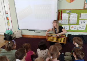Pani tłumaczy dzieciom zasady liczenia na liczydle metodą arytmetyki mentalnej