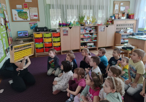 Pani tłumaczy dzieciom zasady liczenia na liczydle metodą arytmetyki mentalnej