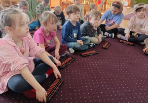 Dzieci wykonują zadania na liczydle z arytmetyki mentalnej