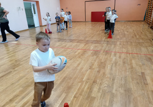 Dzieci trenują bieg z piłką do rugby