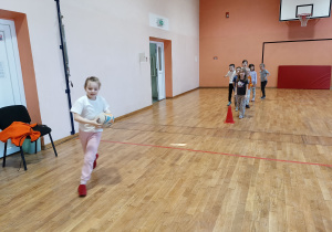 Dzieci trenują bieg z piłką do rugby