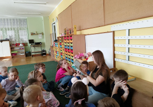 Dzieci siedzą w koło mamy Olka i uważnie słuchają bajki