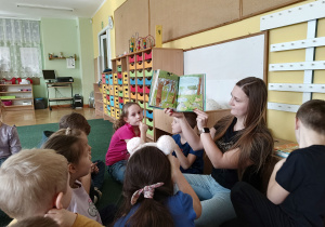 Mama Olka pokazuje dzieciom ilustracje książki