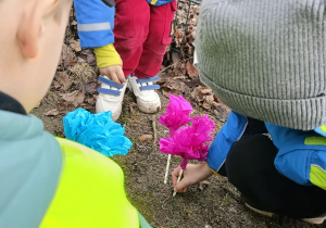 Dzieci sadzą wykonane własnoręcznie kwiaty w ogrodzie przedszklonym