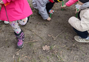 Dzieci sadzą wykonane własnoręcznie kwiaty w ogrodzie przedszkolnym