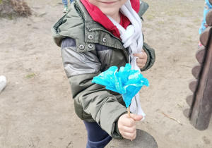 Chłopiec trzyma w ręku kwiat z bibuły