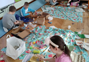 Dzieci wykonują konstrukcje z materiałów do powtórnego przetworzenia.