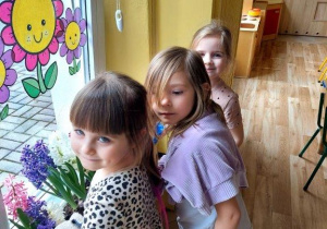 Dzieci dbają o kącik przyrodniczy, podlewają kwiaty