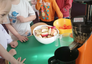 Dzieci obserwują, jak robi się sok w sokowirówce