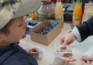 Chłopiec płaci za zakupy