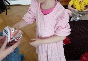 Dziewczynka demonstruje prawidłowe mycie zębów