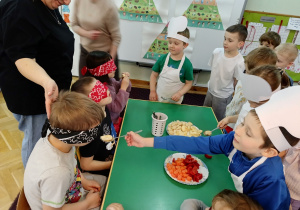 Dzieci z zawiązanymi oczami próbują owoców i warzyw. Zgadują, co zjadły.