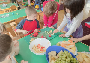 Dzieci kroją owoce do sałatki owocowej