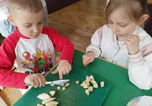 Dzieci kroją owoce do sałatki owocowej