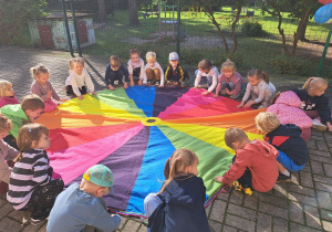 Grupa II - zabawa z chustą animacyjną - do piosenki "Po kole krązy plotka".