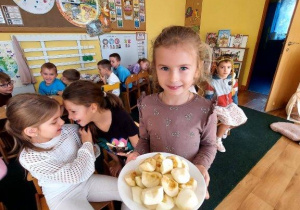 Dziewczynka częstuje dzieci jabłkami
