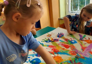 Dzieci odciskają dłonie pomalowane farbą