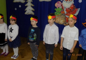 Dzieci z grupy Elfów śpiewaja piosenkę i mówią wiersz na występie choinkowym.