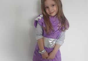 Dziewczynka w sukience z folii plastikowej i biżuterią z folii aluminiowe