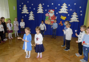 Dzieci stoją z instrumentami i czekają na zakończenie utworu.