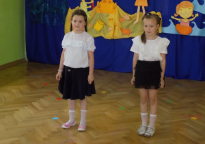 Dwie dziewczynki witają na uroczystym zakończeniu roku przedszkolnego