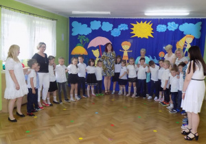 Dzieci śpiewają piosenkę na pożegnanie przedszkola wraz z paniami i panią dyrektor.