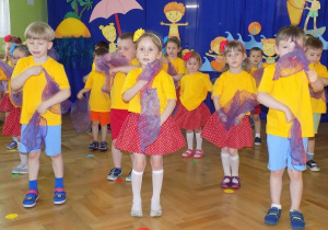 Dzieci tańczą z kolorowymi chusteczkami
