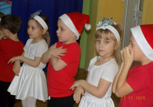 Dzieci śpiewają piosenkę na występie choinkowym.